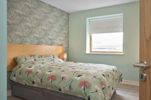 a bedroom with a bed with a comforter and a window at Luxury Apartment near O'Connell Street in Dublin