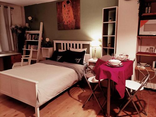 une chambre avec un lit, une table et des chaises dans l'établissement la belle evasion Paris, à Paris