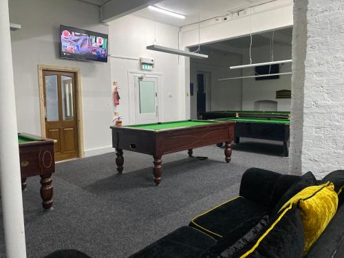 a living room with a pool table and a tv at King Street Hotel in Blackburn