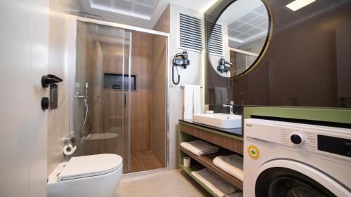y baño con ducha, aseo y lavamanos. en VESTA SUITES, en Antalya