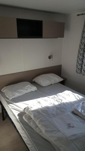 聖讓－德蒙的住宿－mobile home 477 Bois Dormant camping 4*，一张床上有两个枕头的房间
