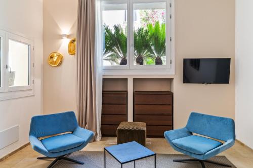 2 blaue Stühle in einem Wohnzimmer mit Fenster in der Unterkunft AuriSPA 143 CON PISCINA NOTO CENTRO in Noto