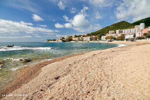 une plage de sable avec des bâtiments et l'océan dans l'établissement Ajaccio Studio Parc Berthault / Albert 1er, à Ajaccio