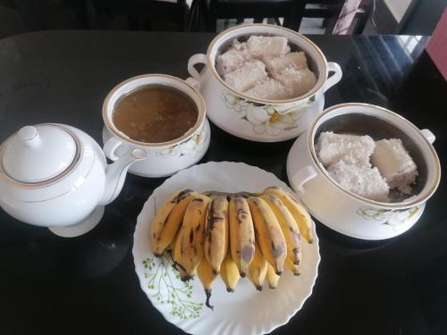 a table with two cups of coffee and a plate of bananas at Dune Homestay in Alleppey