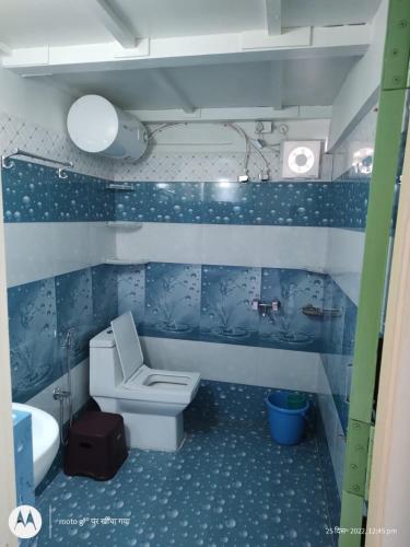 a blue bathroom with a toilet and a sink at The Moon Light Home stay in Bhīm Tāl