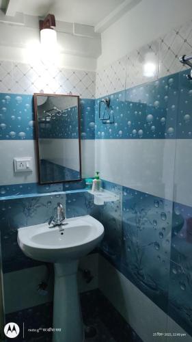 a bathroom with a sink and a mirror at The Moon Light Home stay in Bhīm Tāl