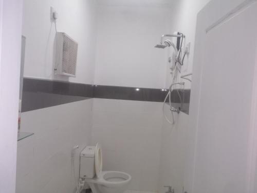 a white bathroom with a shower and a toilet at Glenview hotel & homestay in Kandy