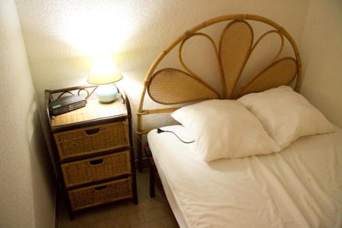 une chambre avec un lit et une table de chevet avec une lampe dans l'établissement Résidence Les Estivales Le Cap D'Agde, au Cap d'Agde