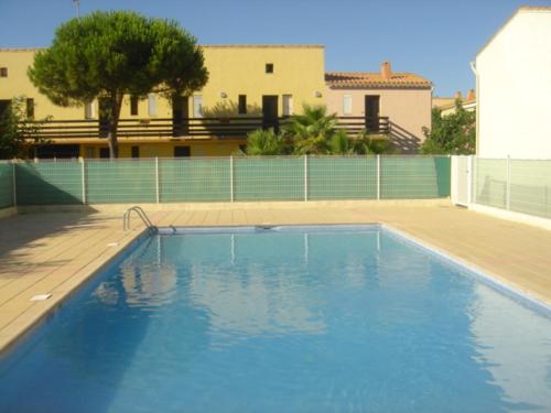 une grande piscine bleue devant un immeuble dans l'établissement Résidence Les Estivales Le Cap D'Agde, au Cap d'Agde