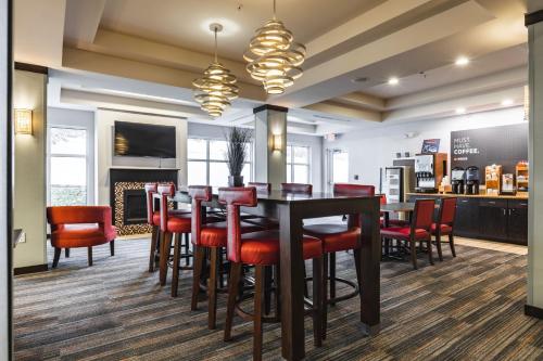 uma sala de jantar com uma mesa e cadeiras vermelhas em Holiday Inn Express & Suites New Martinsville, an IHG Hotel em New Martinsville