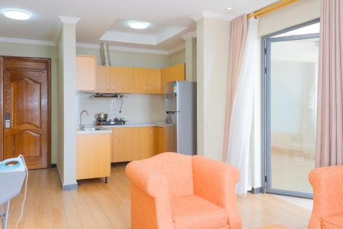 a kitchen with an orange chair in a room at Tropical Plaza Apartments in Kigali