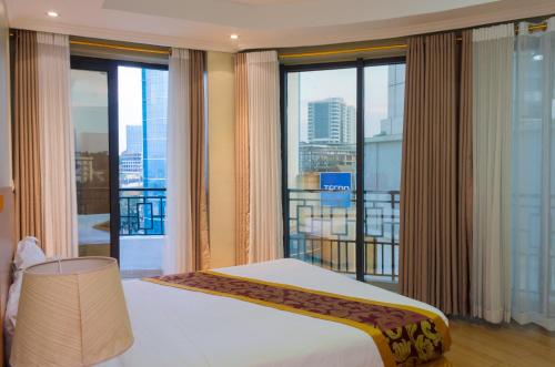 a bedroom with a bed and a large window at Tropical Plaza Apartments in Kigali