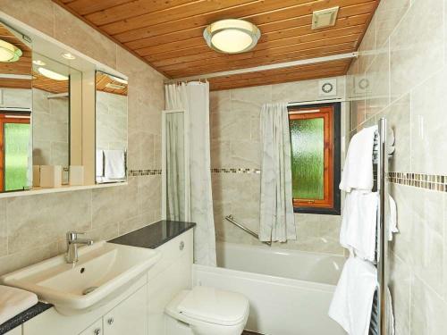 ein Badezimmer mit einem Waschbecken, einem WC und einer Badewanne in der Unterkunft Rowan Lodge 3 Hot Tub in York