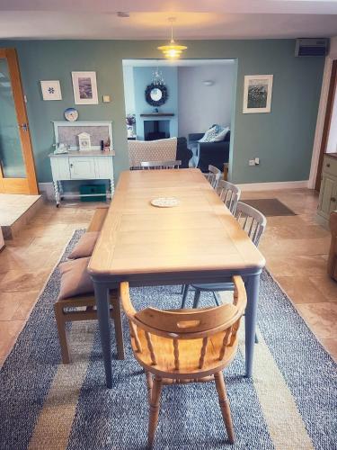a dining room with a wooden table and chairs at Odun Terrace in Appledore