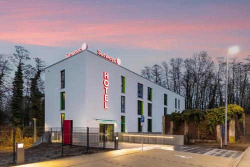 a white building with a red sign on it at Serways Hotel Hösel in Ratingen