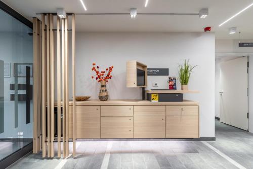 a kitchen with a wooden cabinet in a room at Serways Hotel Hösel in Ratingen