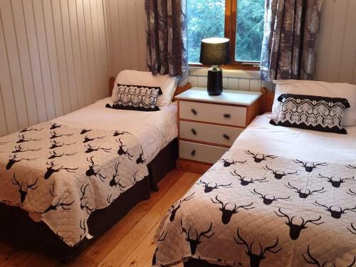 1 dormitorio con 2 camas y ventana en Willow Lodge 13 Hot Tub en York