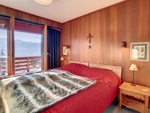 a bedroom with a red bed and a cross on the wall at Porthos 29-30 in Verbier