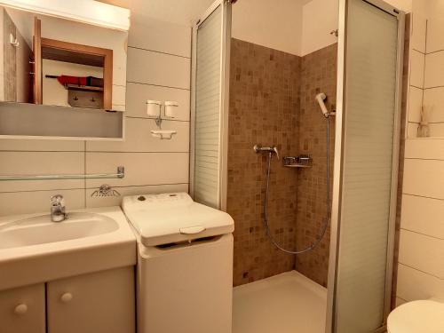 een badkamer met een douche, een wastafel en een toilet bij Porthos 29-30 in Verbier