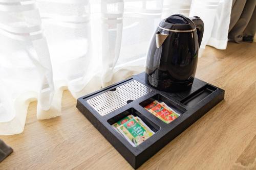 a coffee pot sitting on a tray on the floor at Hotel Olanesti & Spa Medical in Băile Olăneşti
