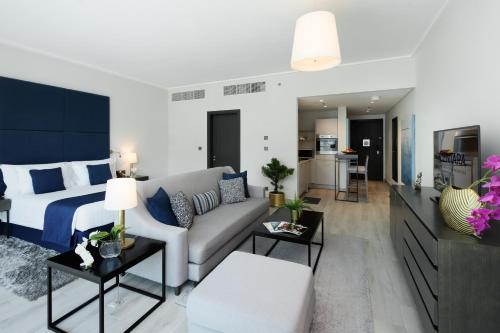 a bedroom and living room with a bed and a couch at Centara West Bay Hotel & Residences Doha in Doha
