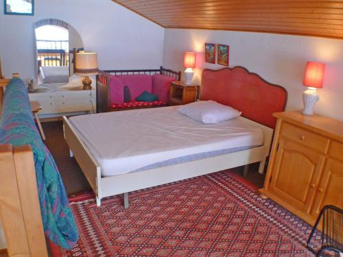 une chambre avec un grand lit avec une tête de lit rouge dans l'établissement Appartement ensoleillé avec balcon, animaux admis, proche du centre de Samoëns - FR-1-629-24, à Samoëns