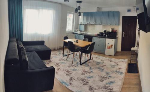 a living room with a couch and a table and a kitchen at Cavnic Hills Apartments in Cavnic