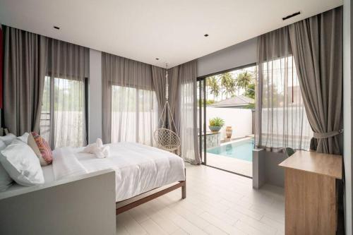 een slaapkamer met een bed en een zwembad bij KOTE Private Pool Villa in Nathon Bay