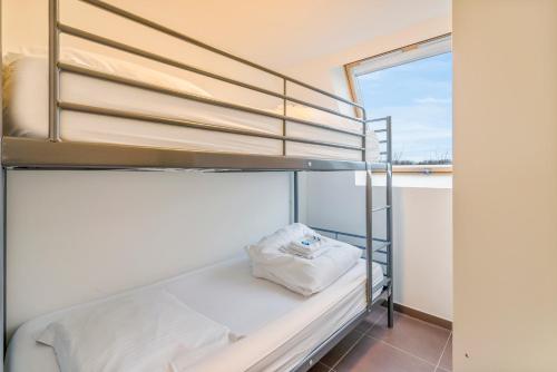 Łóżko piętrowe w pokoju z oknem w obiekcie Casa Kids w mieście De Panne