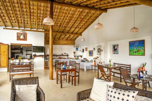 um restaurante com mesas e cadeiras e uma cozinha em Pousada Mar à Vista em Trancoso