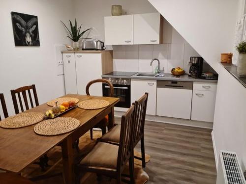 a kitchen with a wooden table with chairs and a dining room at Pilgrims "Rosalie" große Fewo mit 3 Schlafzimmern, 1Bad, 2 WC, Balkon, fast Internet in Brilon