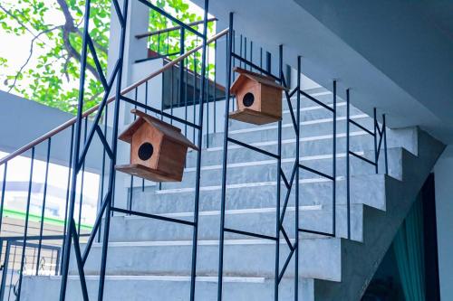 two wooden birdhouses on a metal staircase at Jamjuree Home at Udonthani in Udon Thani