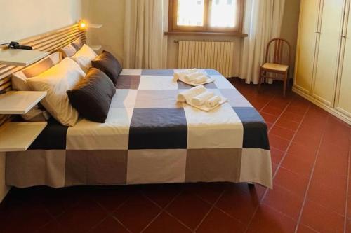 ein großes Bett mit einer schwarz-weißen Decke drauf in der Unterkunft [TERME] CASA IN STILE CLASSICO IN TOSCANA CON TERRAZZO in Montecatini Terme