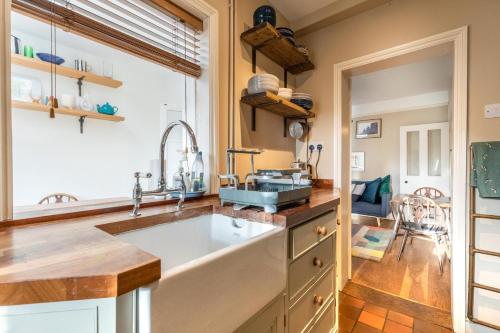 a kitchen with a large sink and wooden counters at Lindley Terrace - Norfolk Holiday Properties in Norwich