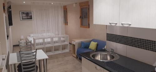 una cocina con fregadero y un sofá en una habitación en Casa Gran Vista, Studio, Adults only, en Jalón