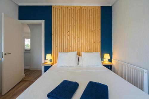 a bedroom with a large bed with two blue pillows at Casa Velazquez in Rojales
