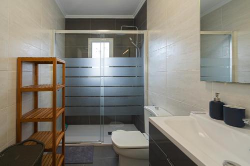 a bathroom with a toilet and a sink and a shower at Casa Velazquez in Rojales