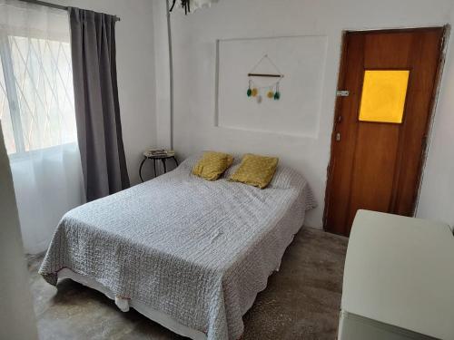 Un dormitorio con una cama con almohadas amarillas. en Cómoda casa en El Volcan en San Luis