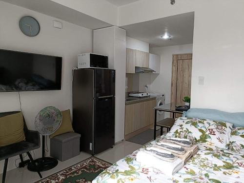 a small room with a bed and a kitchen at Hola! Condotel @ Inspiria Davao in Davao City