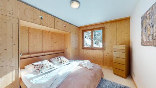 a bedroom with a bed in a wooden wall at Balcons du Soleil QUIET & SUNNY apartments by Alpvision Résidences in Veysonnaz