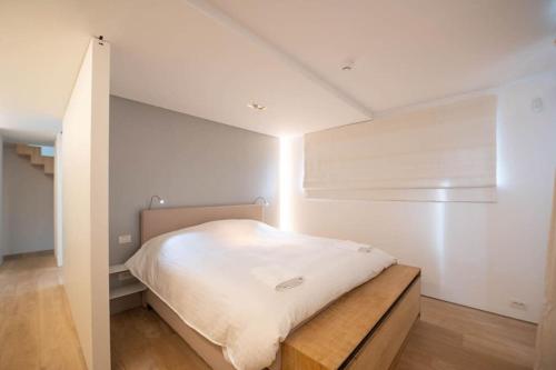 a bedroom with a bed in a white room at Cozy 3BD House with private terrace and parking in Knokke-Heist