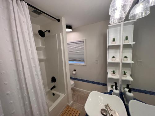 a bathroom with a shower and a toilet and a sink at Casa Madre Chic Lakefront Cottage near Ann Arbor in Whitmore Lake