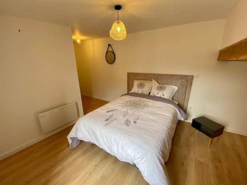 une chambre avec un lit avec une couette blanche dans l'établissement Au bocage parfumé Gîte de la Ciflorette***, à Wirwignes