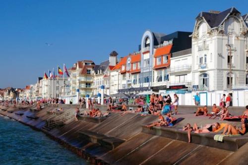 Un groupe de personnes assises sur la plage près de l'eau dans l'établissement Au bocage parfumé Gîte de la Ciflorette***, à Wirwignes