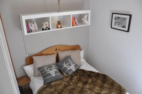a bedroom with a bed with pillows and a shelf at Appartement cosy Peisey Les Arcs 6-8 pers - piscine sauna - en face des pistes in Peisey-Nancroix