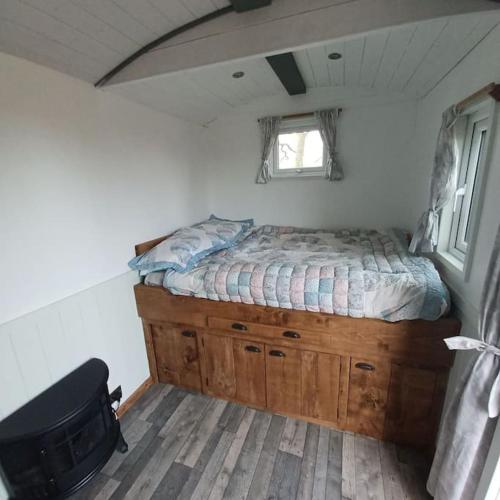 a bedroom with a bed in a tiny house at The Shepherd's Delight in Rushton Spencer