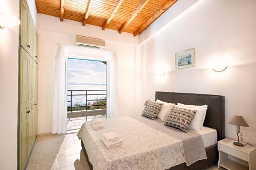 a bedroom with a bed with a view of the ocean at Nissaki Sea View 203 by Sealand Villas in Nisakion