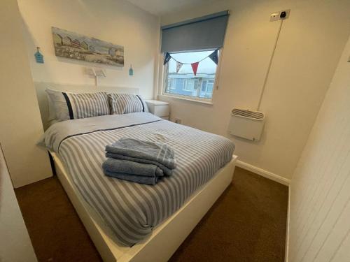 a small bedroom with a bed with towels on it at Wight Waves Holidays in Sandown