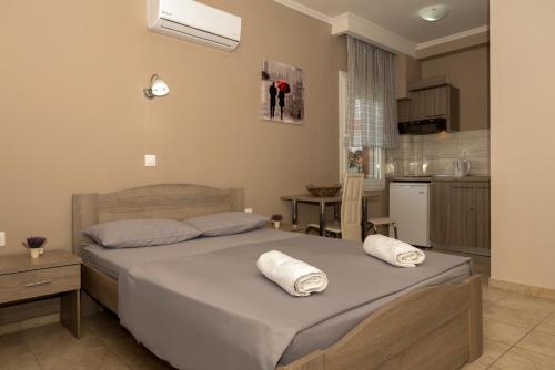 a bedroom with a large bed and a kitchen at Tzamtzis Apartments in Keramoti