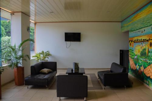 una sala d'attesa con due sedie e una TV di Hotel Orinoquia Real a Yopal